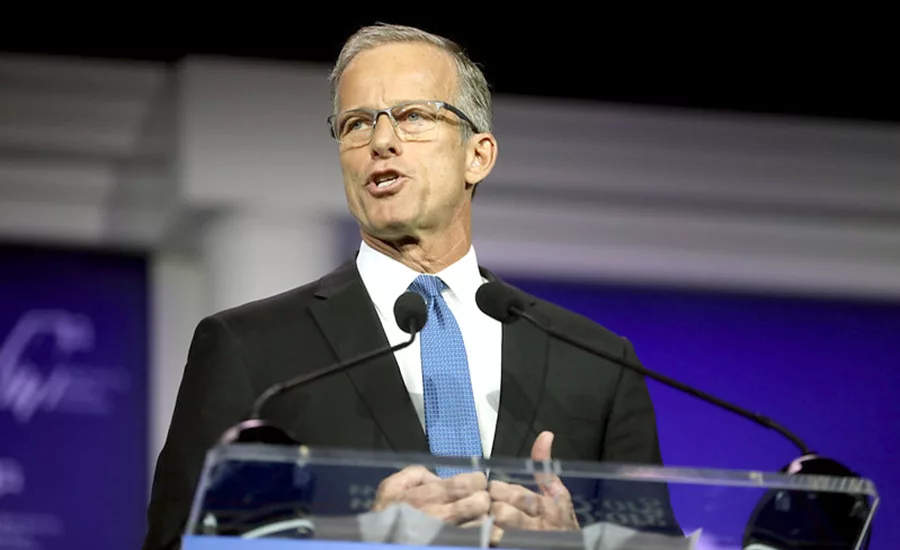 Senate Majority Leader John Thune speaking at a podium during a public event.