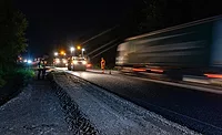 AGC - Safety in Bill.jpg Nighttime highway work zone with workers and passing traffic under active construction conditions.