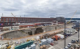 Aerial view of Dry Dock 4 at Puget Sound Naval Shipyard in Bremerton, Wash., with waterfront facilities, construction equipment and support buildings visible.