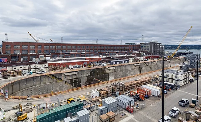 Bremerton-Dry-Dock-4 Aerial view of Dry Dock 4 at Puget Sound Naval Shipyard in Bremerton, Wash., with waterfront facilities, construction equipment and support buildings visible.