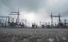 High-voltage transmission substation and power lines on the electric grid.