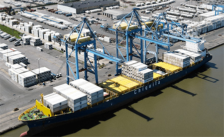 A container ship loads cargo under ship cranes ashore at the existing Port of Wilmington.