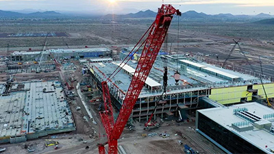 Heavy-lift crane erects a semiconductor fabrication plant under construction at TSMC's Arizona campus in Phoenix.