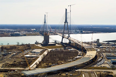 Aerial view of the Gordie Howe International Bridge and Interstate 75 interchange approaching the Detroit River.