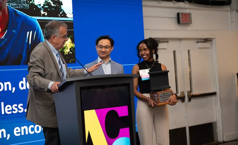 Two members of ACE Greater Boston, including the board president, meet the honorees at a podium at the mentor program event, which raised more than $535,000. 