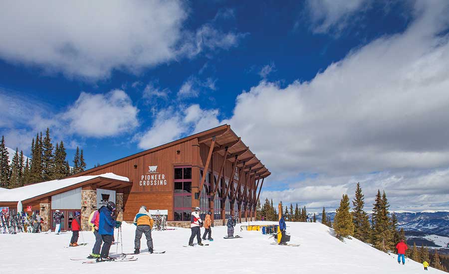 Skiers and snowboarders in front of the Pioneer Crossing restaurant in Breckenridge