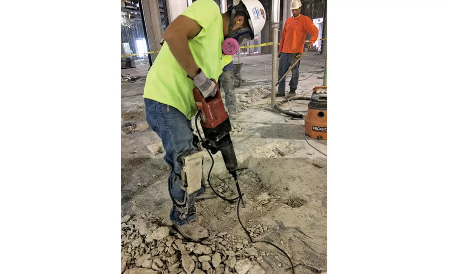 Worker jackhammers concrete