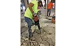 Worker jackhammers concrete