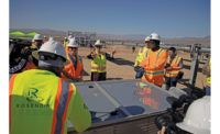 Energy Secretary Granholm talking to construction workers around a solar panel