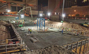 A 10-hour concrete pouring totaling 5,200 cu yds brought the 240-ft-long, 7-ft-deep mat foundation into existence where the Madison Street Parking Garage and 1st Avenue Jail once stood.