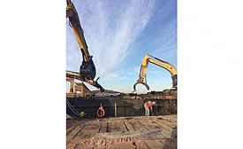 Crews working for subcontractor J.R. Vinagro Corp. load scrap on a work barge left over from demolition of 1950s-era bridges over Boston Harbor