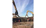 Crews working for subcontractor J.R. Vinagro Corp. load scrap on a work barge left over from demolition of 1950s-era bridges over Boston Harbor