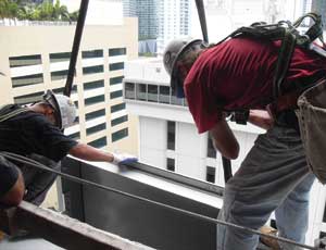 Workers with Enclos Corp. attach a unit of the building’s curtain-wall system, which project team members believe will enable the building to achieve the nation’s highest wind rating.