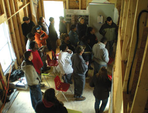Community meetings are a part of the bcWORKSHOP’s approach. Here, one is held in the shell of a home, completed in May 2009. Shown, UTA SOA students, Congo Street residents and workshop members.