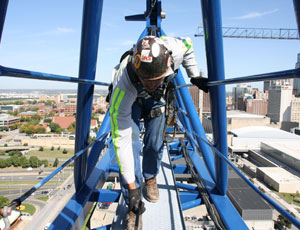 Walking along the counterjib, James Hague of JE Dunn Logistics runs his hands along the rest of the hoist line to check for unsafe conditions.