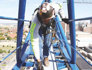 Hanging from a full-body harness, James Hague uses a dial gauge to check the play in a J.E. Dunn tower crane’s turntable in downtown Kansas City, Mo.