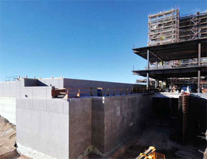 The building rests atop a slab-on-grade foundation with spread footings; it has a steel moment resisting frame for seismic loading and added ductility.