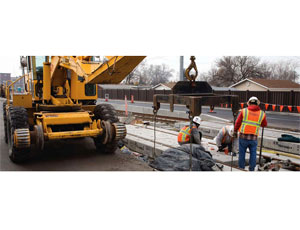 Crews install rail spacers along 2700 West for the West Valley light rail line.