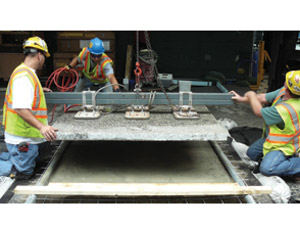  Returning to its original location, a half-ton panel of granite is moved precisely into place by workers at Chicago’s Federal Plaza.