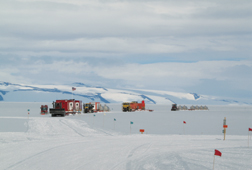 Wheater (Bottom) waves from hanging dozer cab during rescue from crevasse in 1990; Year-4 “Proof of Concept” convoy returns triumphantly to McMurdo Station from 2,000-mile traverse to South Pole in 2006.