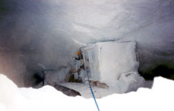 Wheater (Bottom) waves from hanging dozer cab during rescue from crevasse in 1990; Year-4 “Proof of Concept” convoy returns triumphantly to McMurdo Station from 2,000-mile traverse to South Pole in 2006.