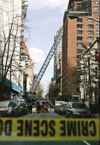 Collars stacked at base of tower. Lower section fell on building across the street while upper tower, cab and luffing jib broke off and flipped into the next block, knocking the side off one building and flattening another. Six of the seven dead worked on the construction.