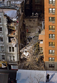 Collars stacked at base of tower. Lower section fell on building across the street while upper tower, cab and luffing jib broke off and flipped into the next block, knocking the side off one building and flattening another. Six of the seven dead worked on the construction.