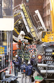 Area around the fallen crane was cordoned off as rescuers searched for missing persons in the rubble of a building.