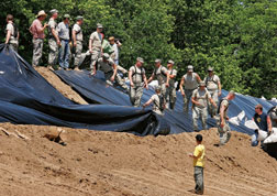 Illinois National Guard troops on sandbagging detail reinforce Mississippi River levee.