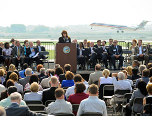 Rosemarie Andolino, executive director of the O’Hare Modernization Program, welcomes guests to the commissioning of a runway extension just as a jet lands. Chicago Mayor Richard Daley is to her right. 