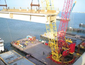 Traylor Bros. crawler cranes mounted on barges take a beating in the humid salt-air environment.