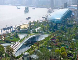 Only visible sign of buried cruise ship terminal, camouflaged by a park with a footbridge, is the glass-clad “bubble” observatory.