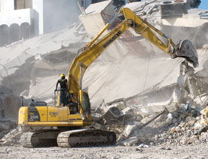 An excavator clears rubble of the Electricite de Haiti building in Port-au-Prince.